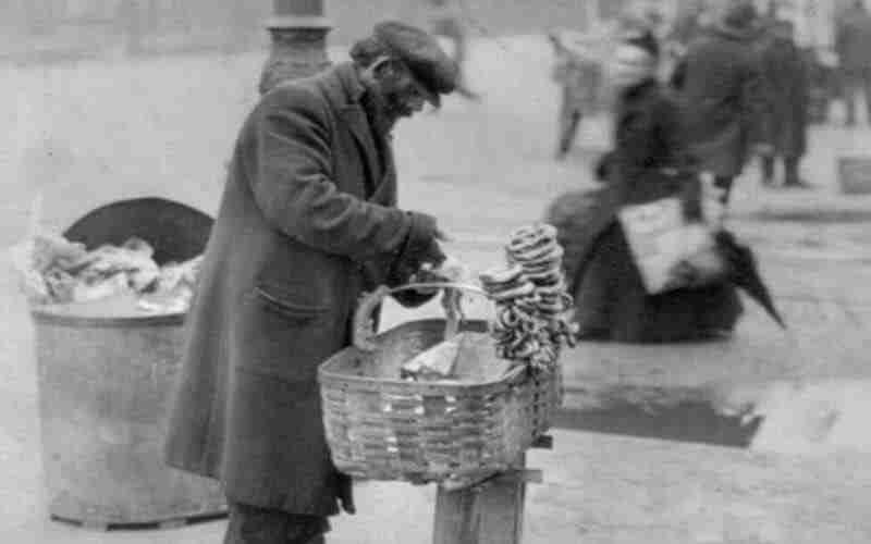 A photo of a street hawker or peddler selling his goods.